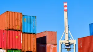 Shipping containers and a crane at a port, representing the logistics and scale of B2B business operations